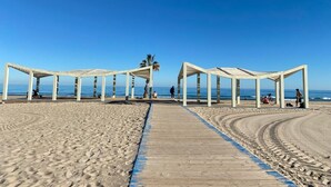 A beach with wooden walkways and white structures, likely gazebos, along the shore. - Comfortable & spacious Villa close from Leana Thermes- Clim & Private pool-  (Fortuna)