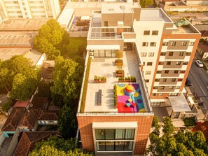 A modern building with a flat roof, large windows, and a colorful mural. - 1 room apartment versatile (Curitiba)