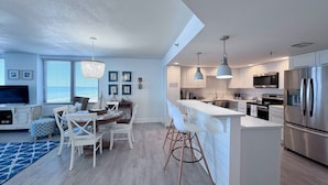 A modern kitchen with a central island, stainless steel appliances, and pendant lighting.