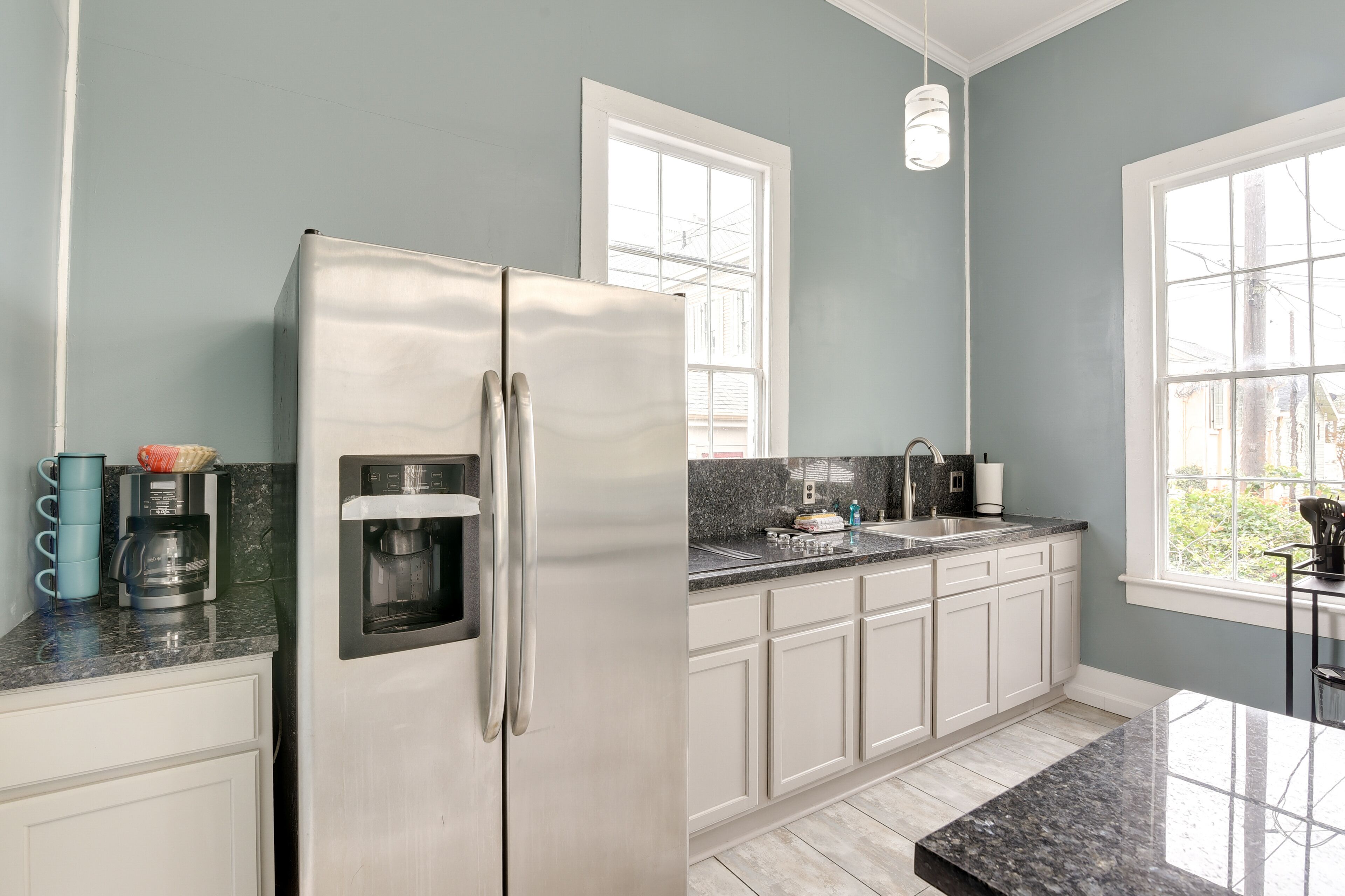 A modern kitchen with a stainless steel refrigerator, a coffee maker, and a built-in water dispenser.