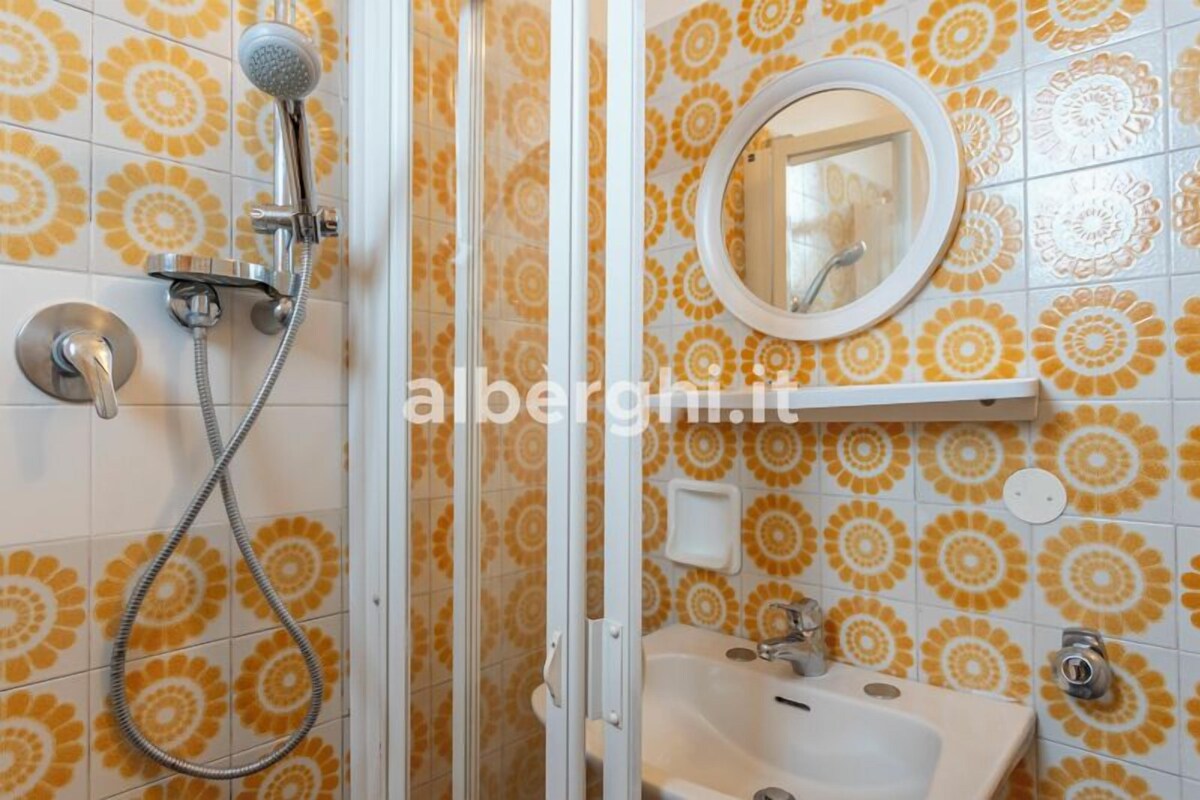 Un baño con ducha, lavabo y espejo.
