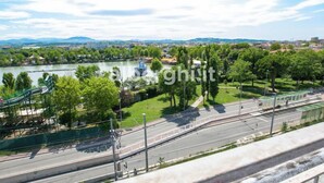 A riverside park with a playground, a bridge, and a road with a tram. - hotel paradiso (Rimini)