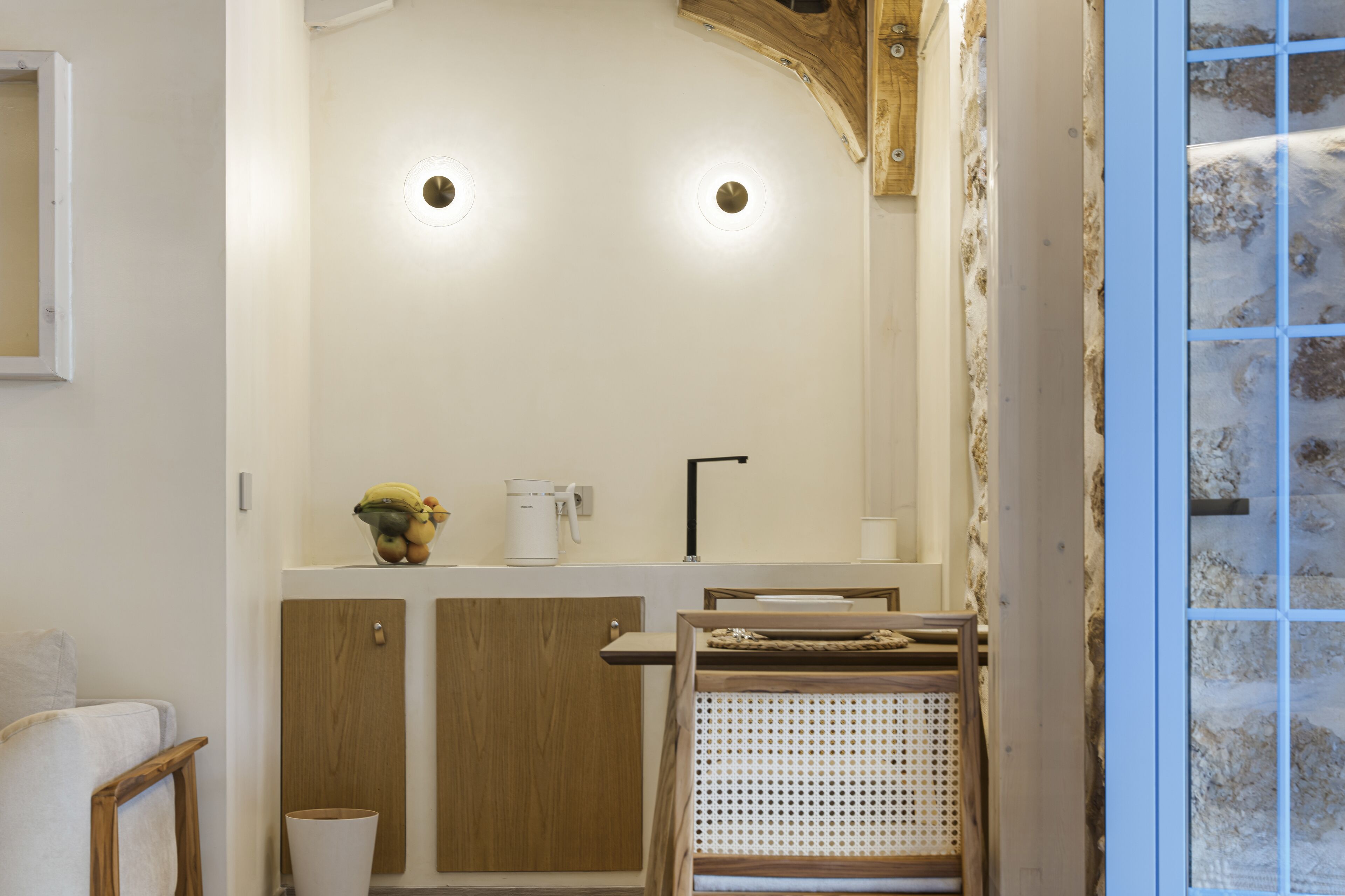A compact kitchen with wooden cabinets, a white countertop, and a built-in sink.