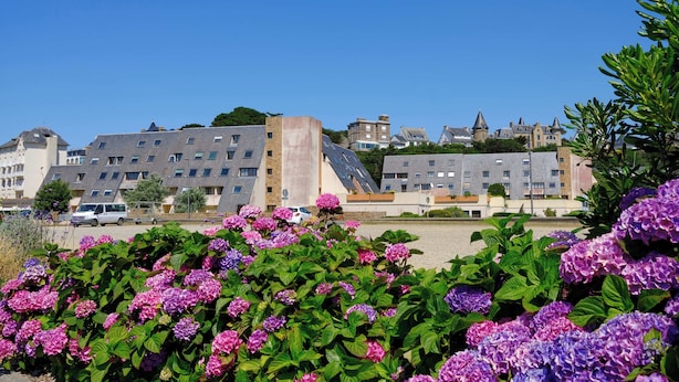 A residential building with a modern architectural style, featuring a mix of flat and sloped roofs, and a prominent tower-like structure. - VVF Côte de Granit Rose à Trébeurden (Trébeurden)