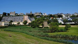 A residential area with houses, a pond, and a bench. - VVF Côte de Granit Rose à Trébeurden (Trébeurden)