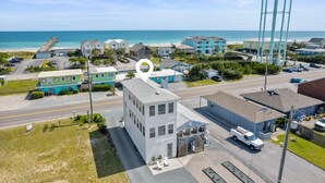 A coastal town with a prominent water tower, a beach, and various buildings including a white two-story building with a truck parked in front. - Guest House Topsail (Holly Ridge)