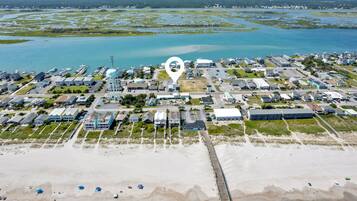 An aerial view of a coastal town with a marina, beach, and a prominent water tower.