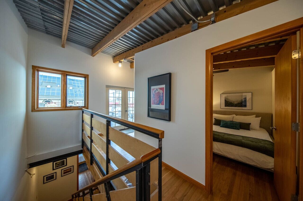 A bedroom with a bed, a wooden door, and a window.