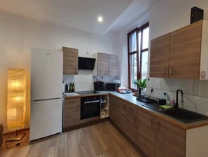 Enjoy cooking in this well-lit kitchen with a central island, refrigerator, microwave, and dishwasher.