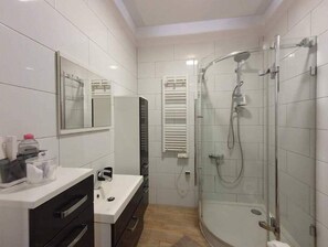 Enjoy a refreshing shower in the bathroom with a glass-enclosed shower area and a sink with a mirror.