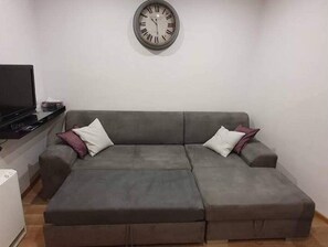 Relax in this stylish living room with a comfortable sofa, flat-screen TV, and convenient storage.