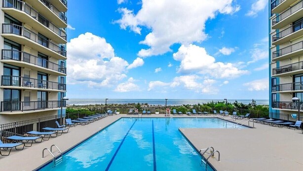 A swimming pool with lounge chairs and a view of the ocean. - Ocean View North OC Oasis - Braemar Towers (Ocean City)