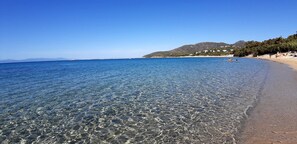 A clear beach with visible pebbles and calm water, a sandy shore, and a mountainous backdrop. - 2-Bedroom Apartment in Tertenia (Tertenia)