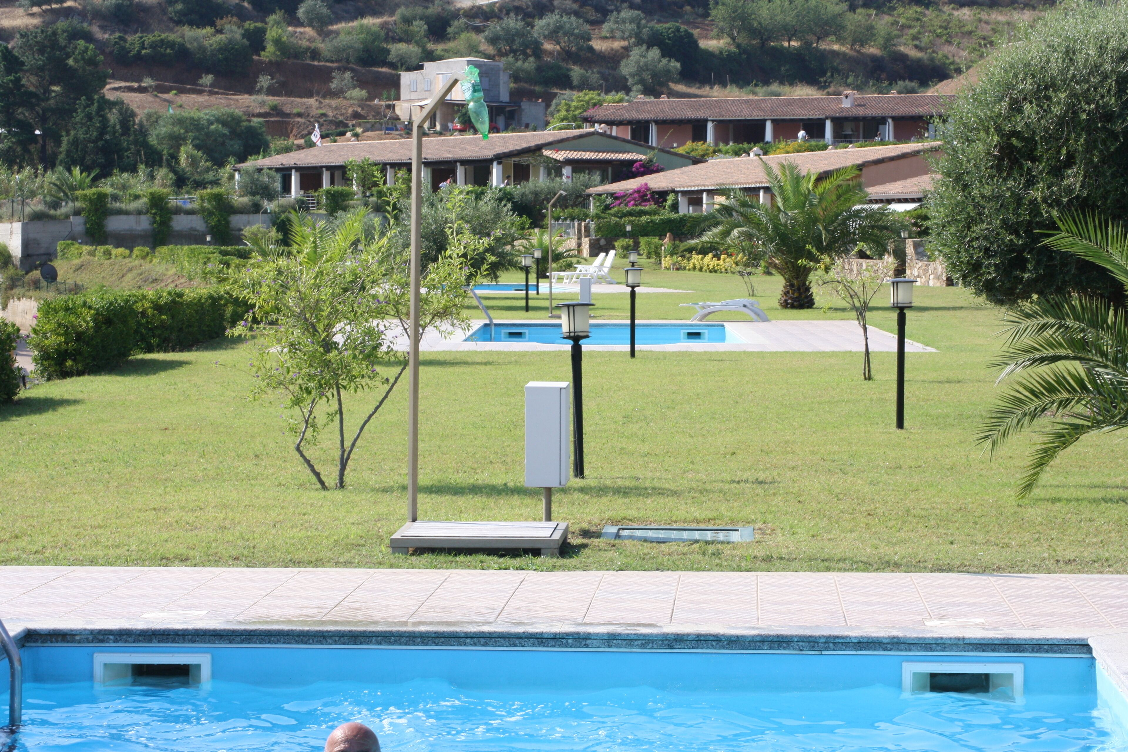 A swimming pool with a view of a hotel complex in the background.