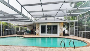 Una piscina interior con agua cristalina, rodeada por un patio techado con detalles de piedra y puertas de cristal.
