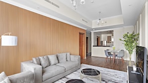 Uma sala de estar moderna com sofá, mesa de centro e área de jantar com cadeiras.