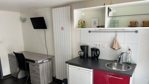 A compact kitchenette with a coffee maker, kettle, and sink. - Studio Pour Votre Séjour à Paris (Châtillon)