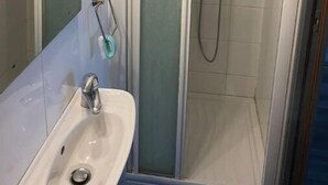 A bathroom with a glass-enclosed shower, a sink, and a mirror. - Studio Pour Votre Séjour à Paris (Châtillon)