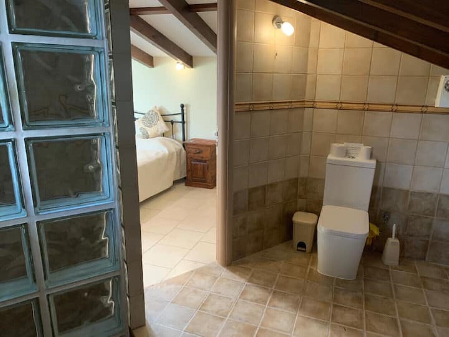 Une chambre à coucher avec un lit, une table de chevet et une petite armoire en bois.