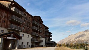 A multi-story hotel with wooden balconies and a stone facade.