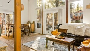 A spacious living room with a large window, a cozy fireplace, and a comfortable seating area.