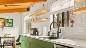 A modern kitchen with green cabinets, white countertops, and wooden beams on the ceiling. - Heart of Big Bear | Lake & Mountain View (Big Bear Lake)
