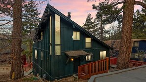 A two-story house with a steep roof, large windows, and a red railing around the porch. - Heart of Big Bear | Lake & Mountain View (Big Bear Lake)