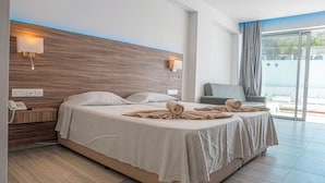 Ein modernes Hotelzimmer mit einem großen Bett, Nachttischlampen, einem Schreibtisch mit Telefon und Blick ins Freie.