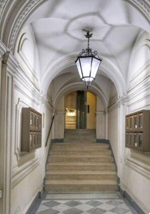 Una imponente escalera de diseño clásico, adornada con molduras decorativas y una lámpara colgante.