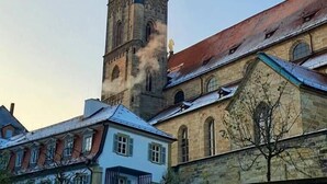 A historic tower with a clock, surrounded by buildings with traditional architecture. - Beckhomes: Luxus-apartment Direkt in der Altstadt (Bamberg)