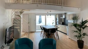 A spacious loft apartment with a mezzanine level, a dining area, and a kitchen. - Maison Pêcheur Cosy Proche Plage et Port 6pers (Les Sables-d'Olonne)