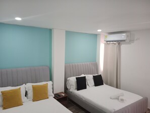 A hotel room with two beds, a grey headboard, white bedding, and an air conditioning unit on the wall. - CC House Cartagena  (Cartagena)