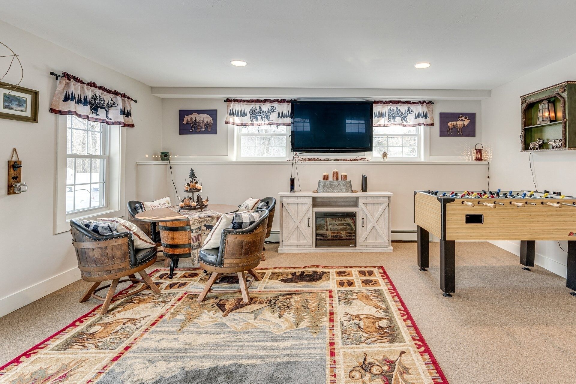 A cozy living room with a fireplace, a foosball table, and a television.