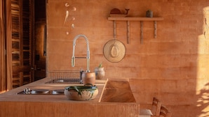 Eine Küche mit einer Holztheke, einem Spülbecken und einem Hut an der Wand.
