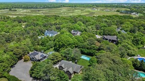 A residential area with multiple houses surrounded by dense trees and a golf course in the background. - Spacious Southampton Home in Shinnecock Hills, Central Between Southampton,... (Southampton)