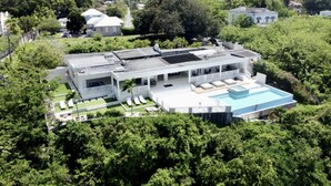 A modern two-story house with a large swimming pool, surrounded by lush greenery. - Luxury 4 Bed Villa in Barbados With Amazing Views (Bridgetown)