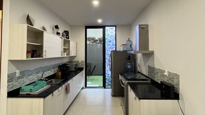 Una cocina moderna con comedor, que incluye una isla de cocina, armarios empotrados y vistas al exterior.