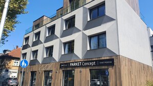 Un edificio moderno con fachada geométrica, con la leyenda 'PARKET Concept'.