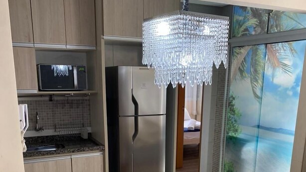 Une cuisine moderne équipée d’un réfrigérateur en acier inoxydable, d’un four à micro-ondes et d’un coin repas avec une table et des chaises.