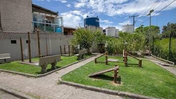 A courtyard with a brick wall, a bench, and a water tank.