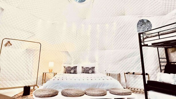 A bedroom with a bunk bed, a large round window, and a quilted ceiling. - The Perch: Glamping by Rafting (Cosby)