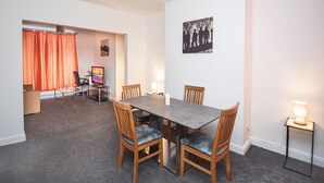 A dining area with a rectangular table, four wooden chairs, and two side tables with lamps. - Captivating 3-bed House in Central Doncaster (Doncaster)