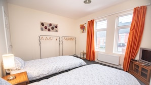 A hotel room with two beds, a television, and a window with curtains. - Captivating 3-bed House in Central Doncaster (Doncaster)