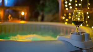Un jacuzzi con una copa de vino tinto.