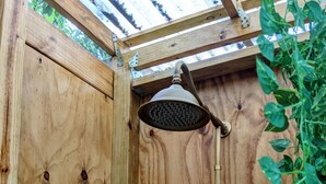 Un box de ducha de madera con un cabezal de ducha de mano y otro cabezal de ducha manual.