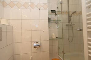 A bathroom with white tiles, a glass shower enclosure, and a toilet. - Diese Schöne Wohnung Befindet Sich in der Käptn Christiansenstraße, Ideale Lage für Erholsamen Strandurlaub, zum Sind es Strand nur ca. 200m. Sie ist ca. 50 m² Groß und Besteht aus Einem Geschmackvoll Eingerichteten Wohnraum/schlafsofa für die 3.pe (Westerland)