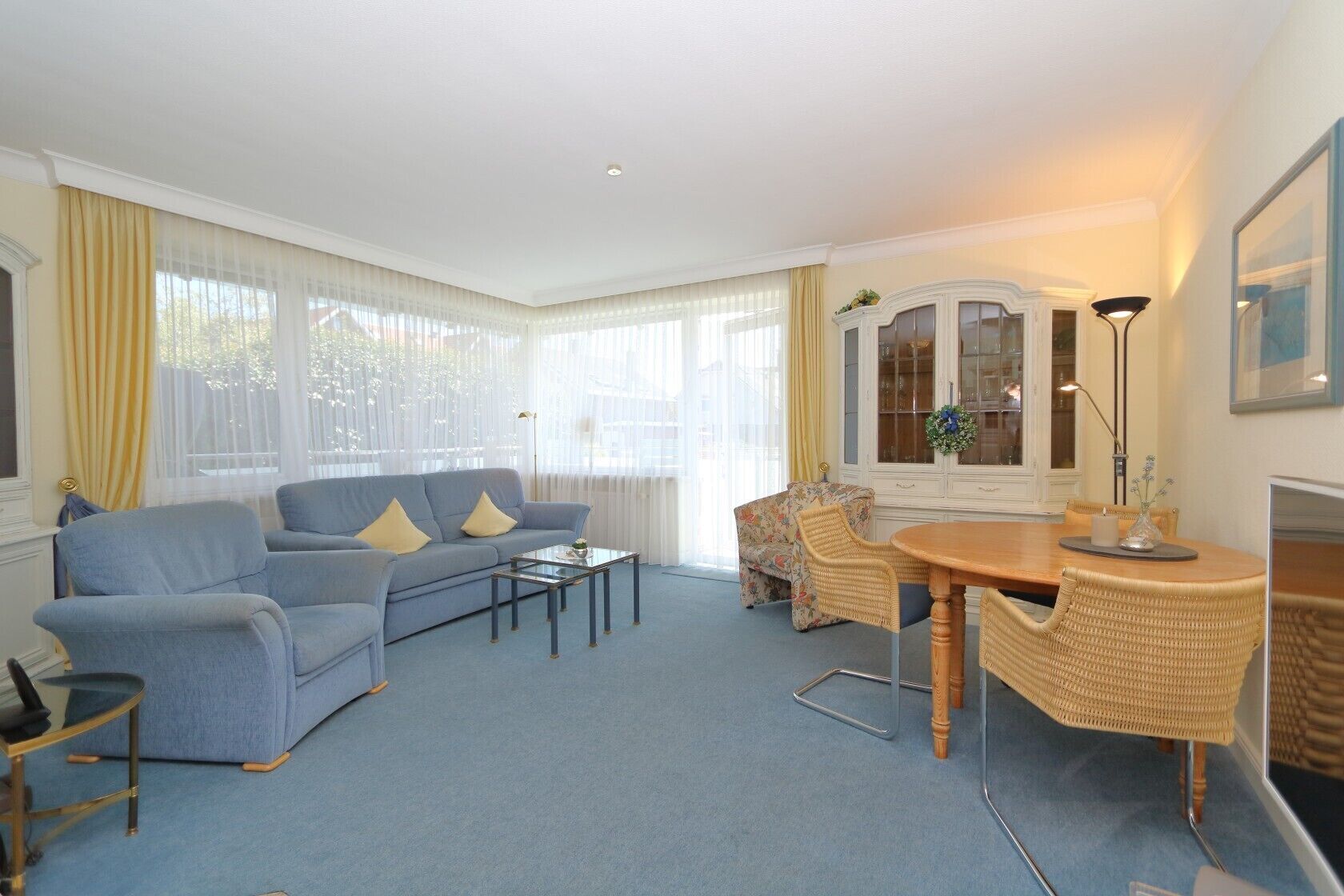 A living room with a sofa, coffee table, dining table, and chairs.