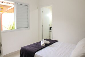 Une chambre d’hôtel avec un lit, une fenêtre et une porte donnant sur une salle de bain.