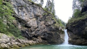 Un paysage naturel comprenant une cascade, de l’eau claire et une végétation luxuriante.