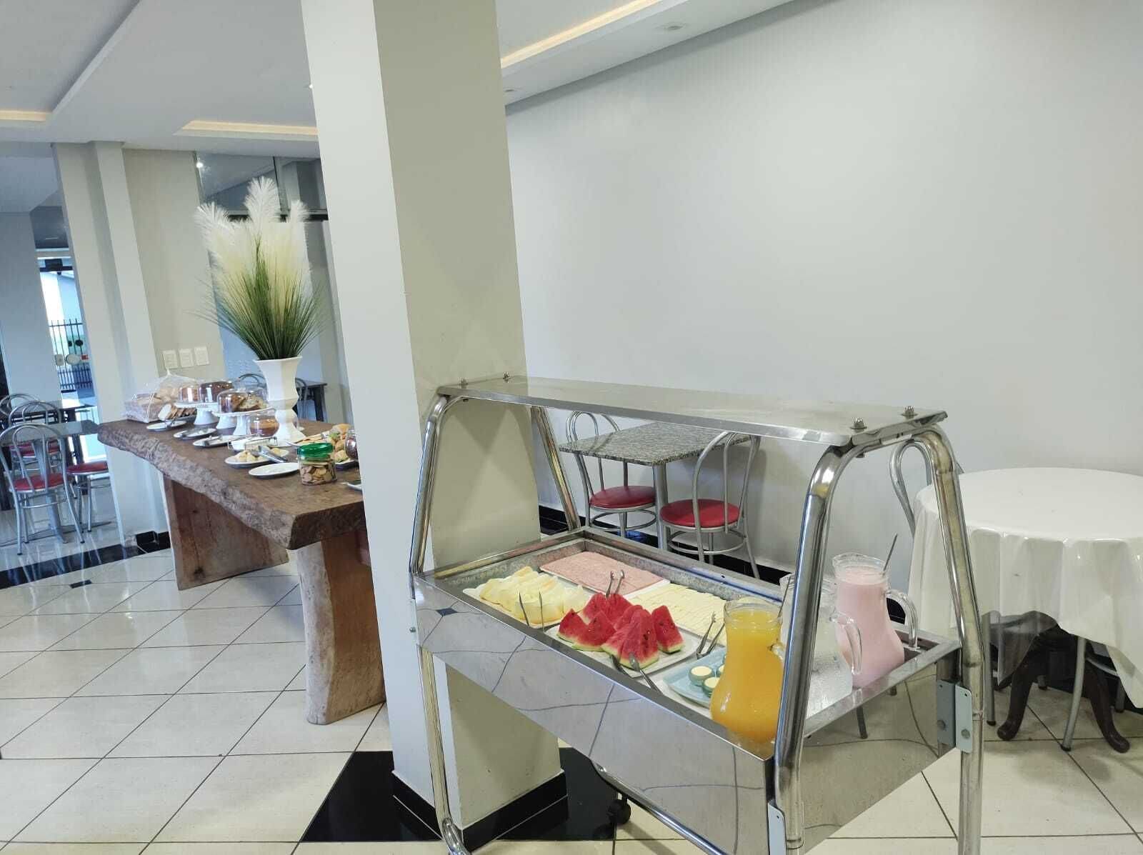 A breakfast buffet area with a variety of food items and a juice dispenser.